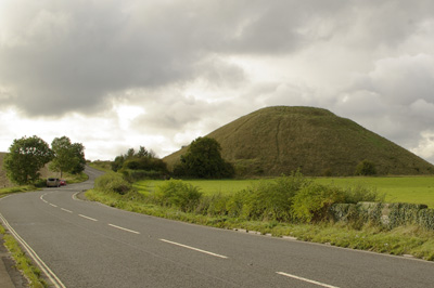 large conical hill towering behind a winding main road